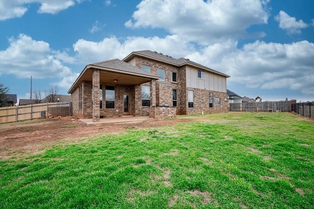 back of house featuring a patio area, a fenced backyard, a lawn, and brick siding