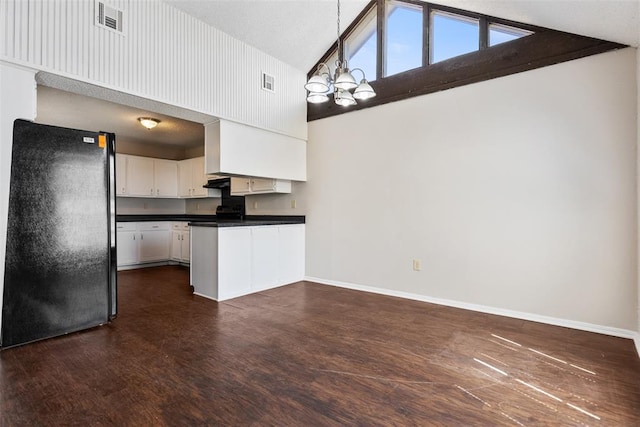 kitchen featuring visible vents, high vaulted ceiling, dark countertops, freestanding refrigerator, and baseboards