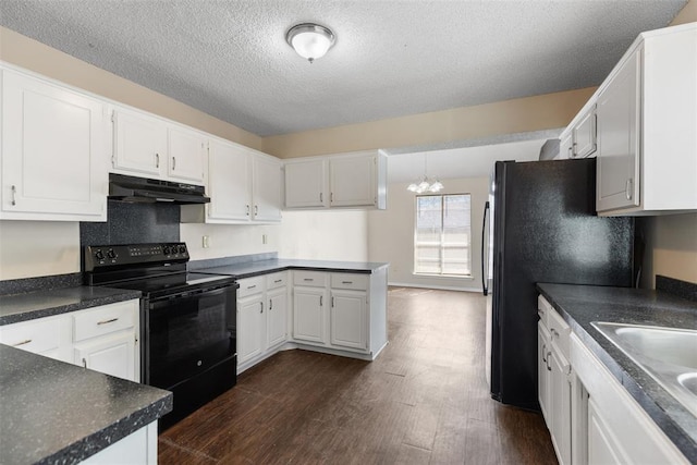 kitchen featuring under cabinet range hood, dark countertops, black appliances, and dark wood finished floors