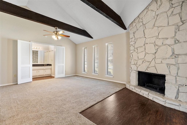 unfurnished living room featuring vaulted ceiling with beams, baseboards, ceiling fan, carpet floors, and a fireplace