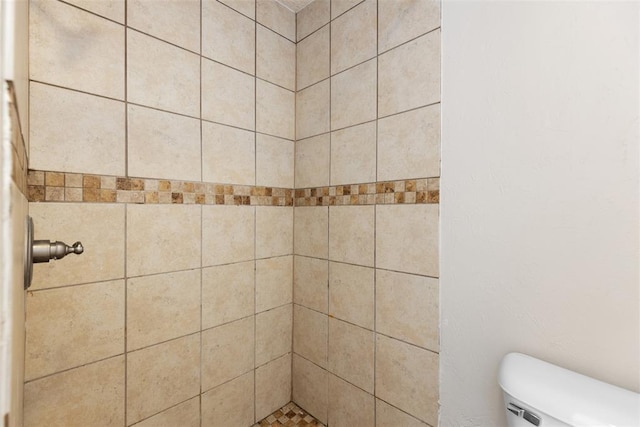 full bath featuring toilet and a tile shower