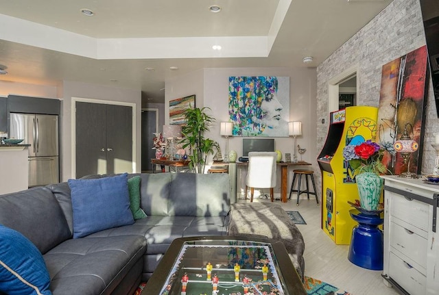 living area featuring a tray ceiling, recessed lighting, and light wood-type flooring