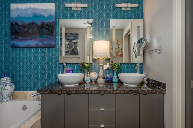 bathroom featuring a sink, decorative backsplash, tiled tub, and double vanity