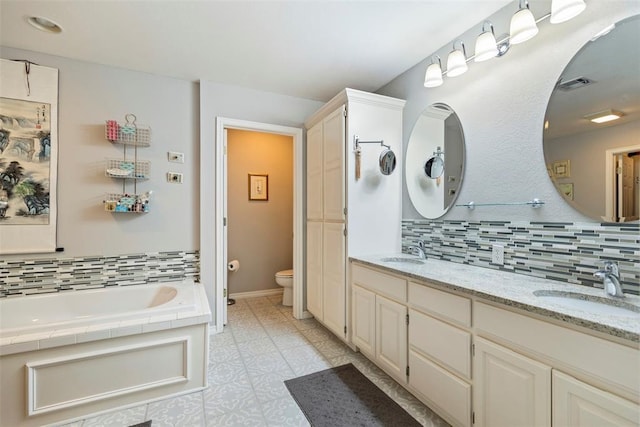 bathroom with tasteful backsplash, visible vents, a sink, and toilet