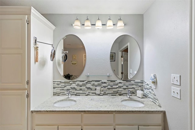 bathroom featuring double vanity, decorative backsplash, and a sink