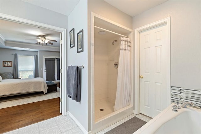 ensuite bathroom featuring a garden tub, a ceiling fan, a stall shower, connected bathroom, and baseboards