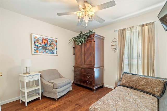 sitting room with ceiling fan, baseboards, and wood finished floors