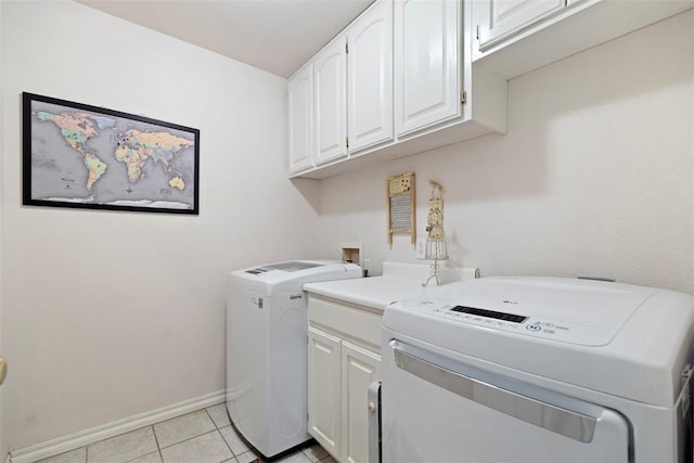 laundry room featuring baseboards, cabinet space, washing machine and clothes dryer, and light tile patterned floors