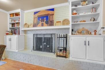 interior space featuring built in shelves, a fireplace, and wood finished floors