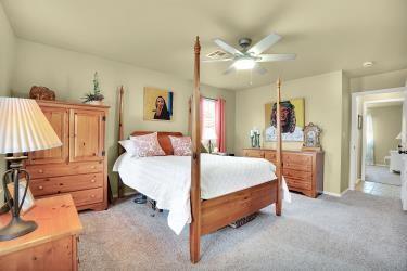 bedroom featuring light carpet and a ceiling fan