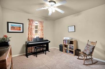 sitting room with carpet floors, a ceiling fan, and baseboards