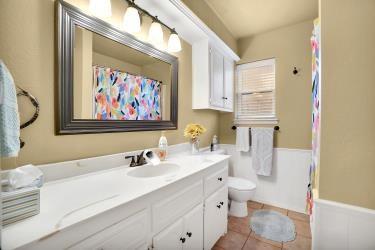 bathroom featuring a shower with shower curtain, toilet, wainscoting, vanity, and tile patterned floors