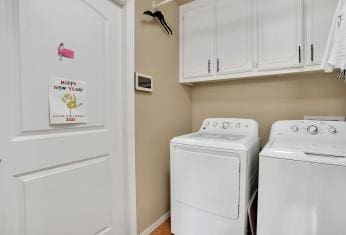 laundry area with cabinet space, baseboards, and separate washer and dryer