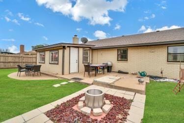 back of house featuring a patio area, an outdoor fire pit, fence, and a yard