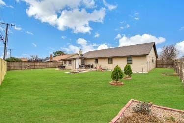 back of house with a lawn and a fenced backyard