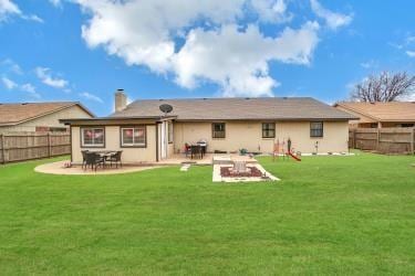 rear view of property with a patio area, a yard, and a fenced backyard