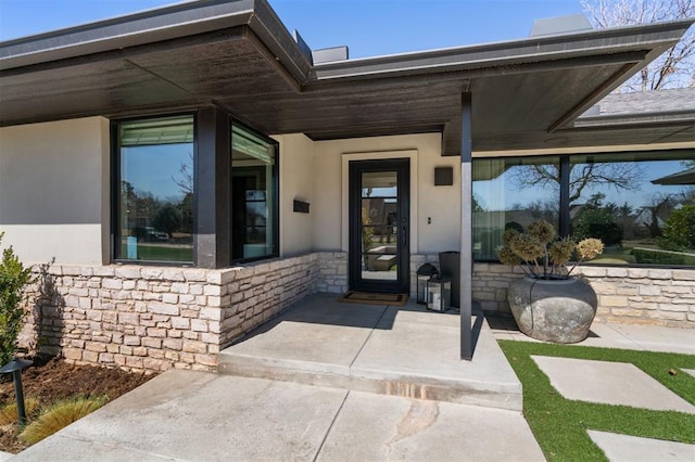 property entrance with stone siding and stucco siding