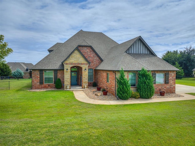 view of front of home with brick siding, roof with shingles, and a front yard