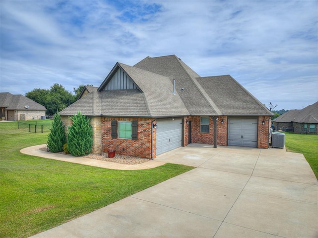 view of front of house with a garage, a front lawn, central AC, and brick siding