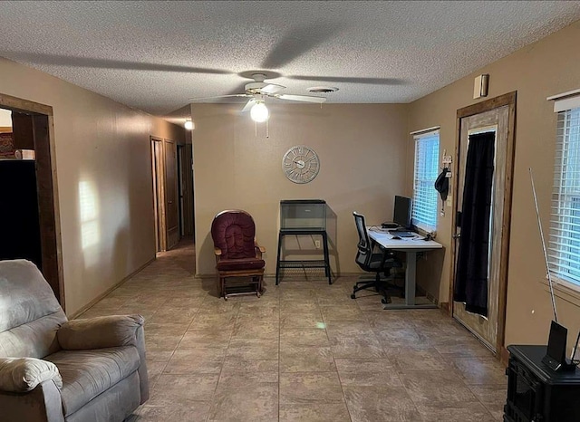 office area featuring ceiling fan, a healthy amount of sunlight, visible vents, and a textured ceiling