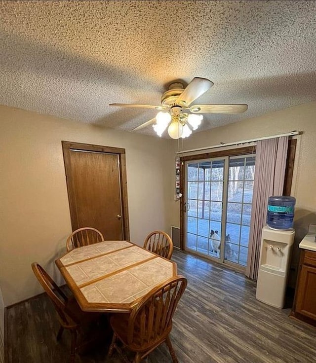 dining area featuring dark wood-type flooring, a ceiling fan, and a textured ceiling