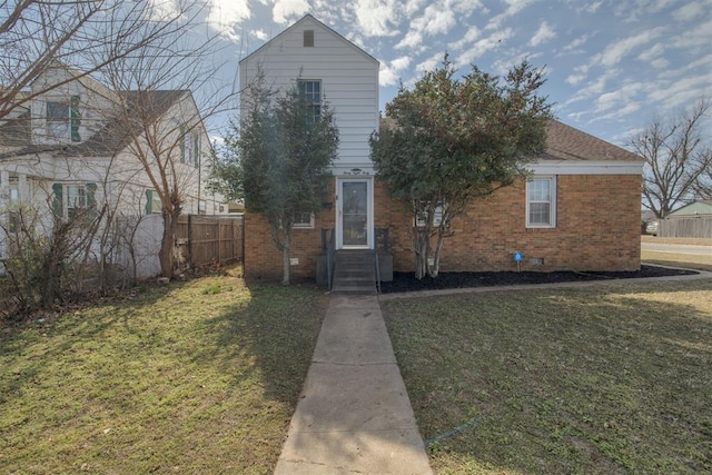 view of front of home with crawl space, fence, a front lawn, and brick siding