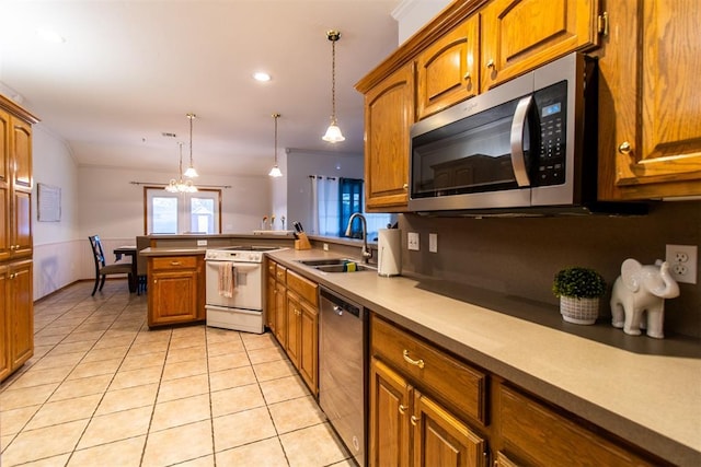 kitchen with light tile patterned floors, appliances with stainless steel finishes, brown cabinets, a peninsula, and a sink