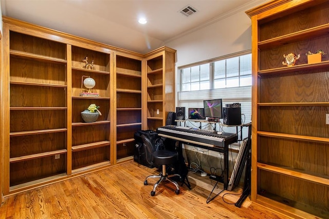 office area with crown molding, visible vents, and wood finished floors