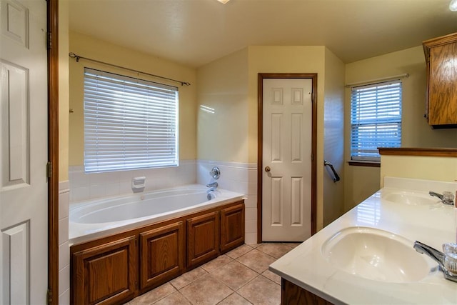 full bath with double vanity, tile patterned flooring, a sink, and a bath