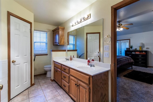 ensuite bathroom featuring tile patterned floors, a sink, toilet, and double vanity