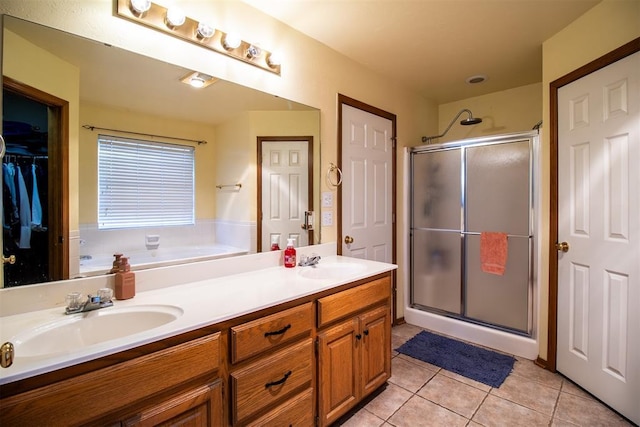 full bath featuring tile patterned flooring, a sink, and a shower stall