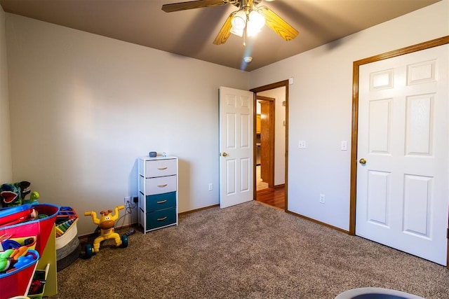 rec room featuring carpet, baseboards, and a ceiling fan