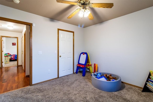 recreation room with ceiling fan, carpet floors, and baseboards