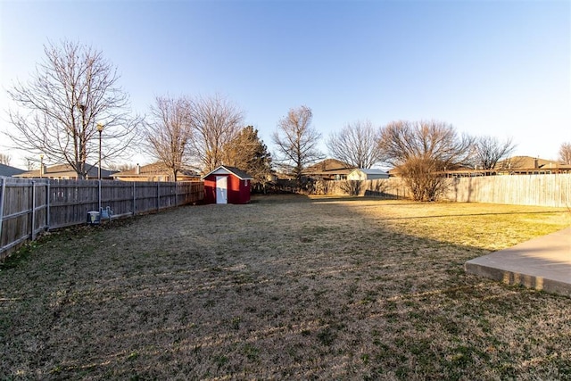 view of yard with an outbuilding, a storage shed, and a fenced backyard