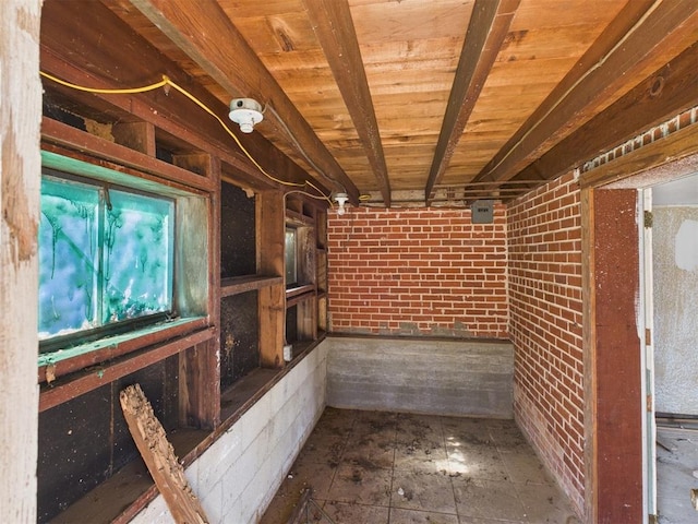 wine cellar featuring beam ceiling, wood ceiling, and brick wall