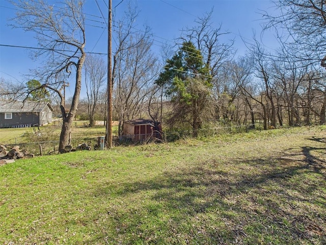 view of yard with an outbuilding, a storage shed, and fence