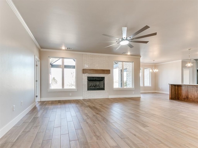 unfurnished living room featuring light wood-style floors, plenty of natural light, a fireplace, and visible vents