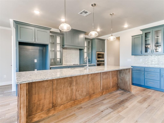 kitchen with stainless steel appliances, a sink, visible vents, light wood finished floors, and crown molding