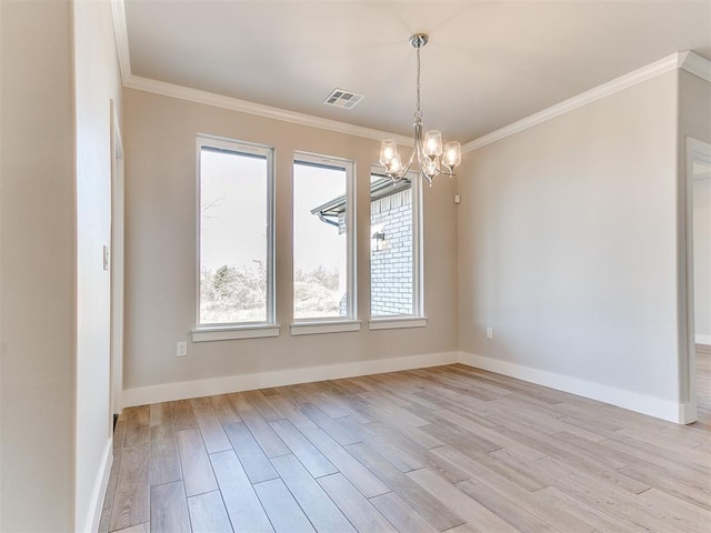 spare room with a chandelier, light wood finished floors, and crown molding