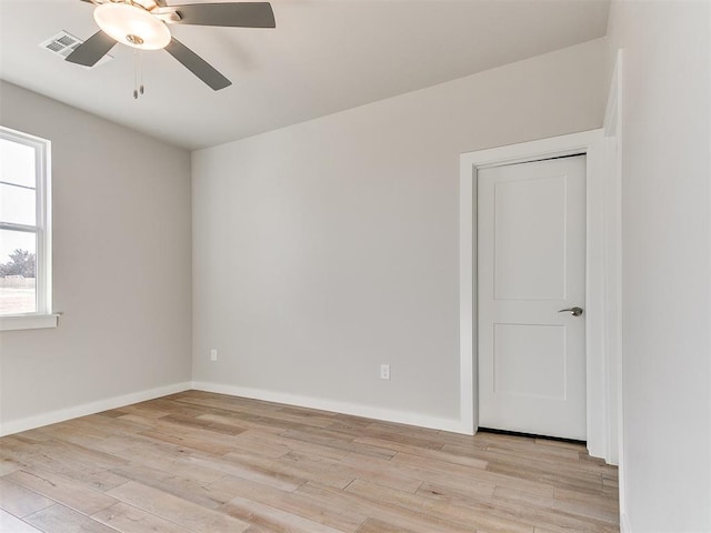 spare room with ceiling fan, light wood-style flooring, visible vents, and baseboards