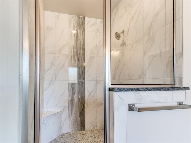 bathroom featuring a marble finish shower