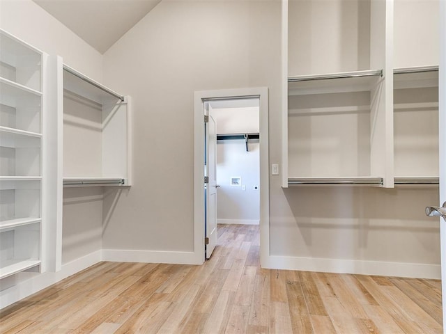 spacious closet with lofted ceiling and wood finished floors