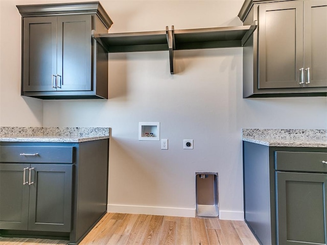 laundry area featuring washer hookup, cabinet space, hookup for an electric dryer, light wood-type flooring, and baseboards