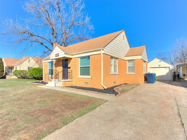 bungalow-style house featuring an outbuilding, brick siding, a detached garage, a front yard, and crawl space