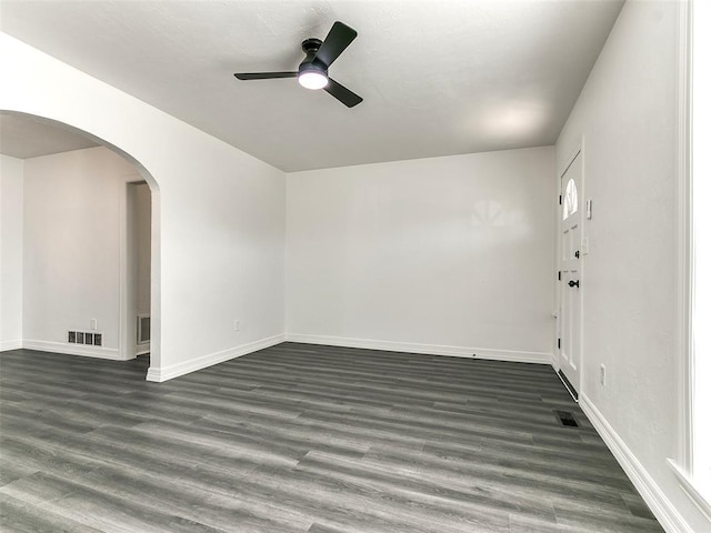 2208 N Hood St, Oklahoma City, OK 73111 - spare room with ceiling fan, arched walkways, baseboards, and dark wood-style floors
