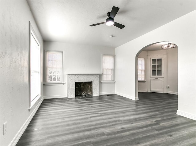 2208 N Hood St, Oklahoma City, OK 73111 - unfurnished living room with wood finished floors, arched walkways, a ceiling fan, healthy amount of natural light, and a textured wall
