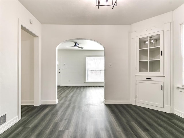 2208 N Hood St, Oklahoma City, OK 73111 - unfurnished dining area with arched walkways, dark wood finished floors, and baseboards