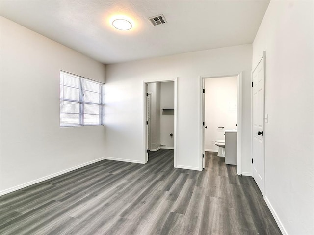 2208 N Hood St, Oklahoma City, OK 73111 - unfurnished bedroom featuring dark wood finished floors, baseboards, a spacious closet, a closet, and ensuite bath