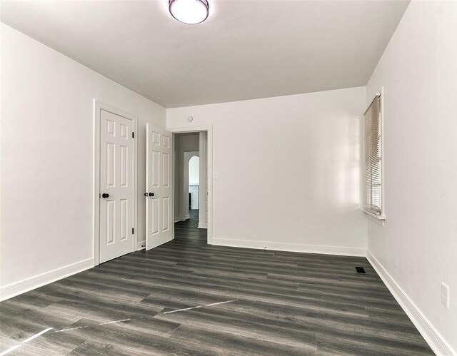 2208 N Hood St, Oklahoma City, OK 73111 - spare room with baseboards, dark wood-style floors, and arched walkways