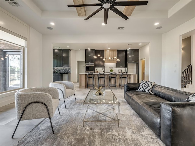 living room featuring recessed lighting, a raised ceiling, and visible vents